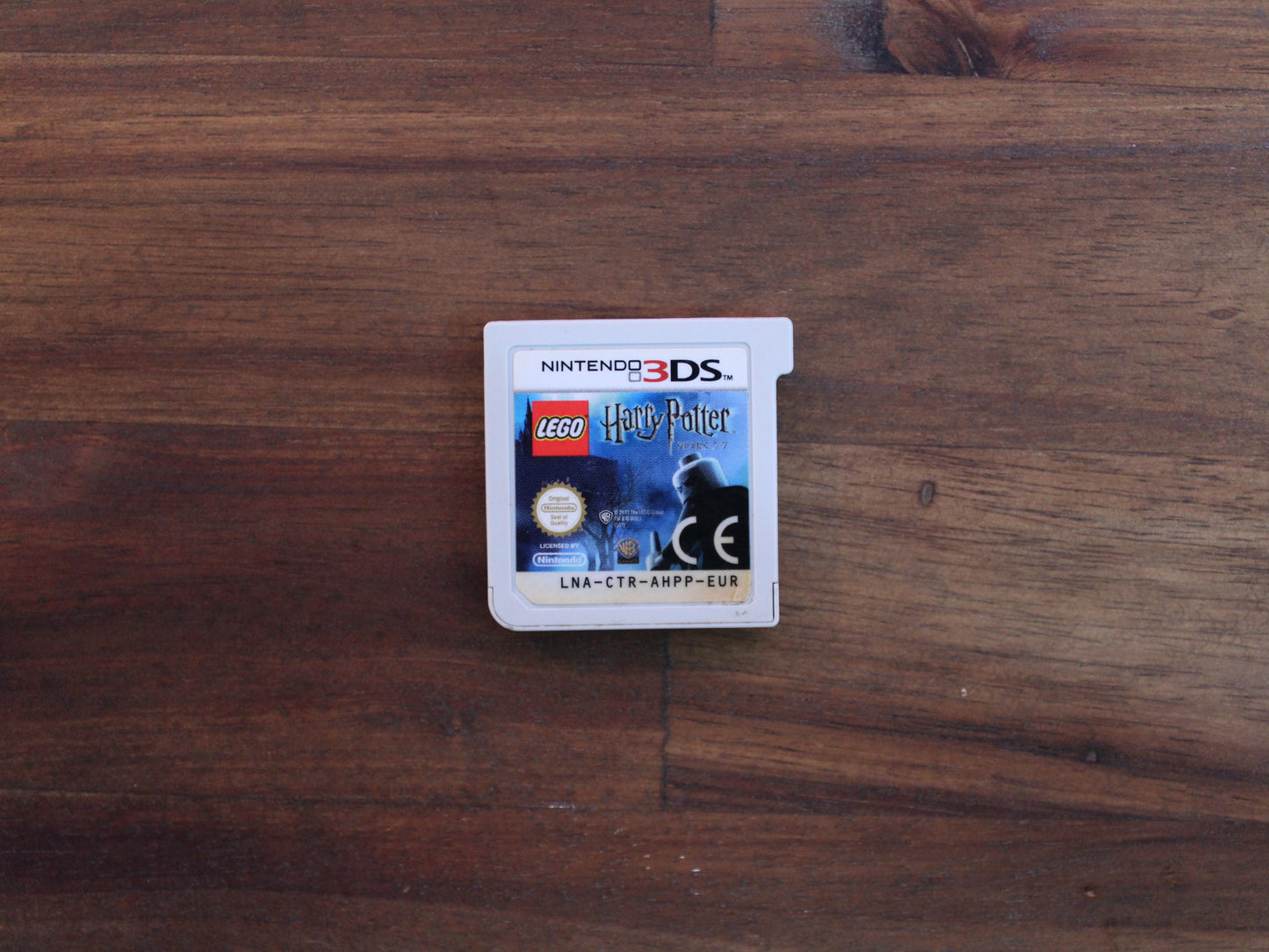 Nintendo 3DS game card for 'LEGO Harry Potter' on a wooden surface