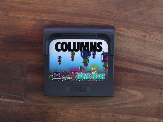 Sega Game Gear game cartridge with 'Columns' on a wooden surface