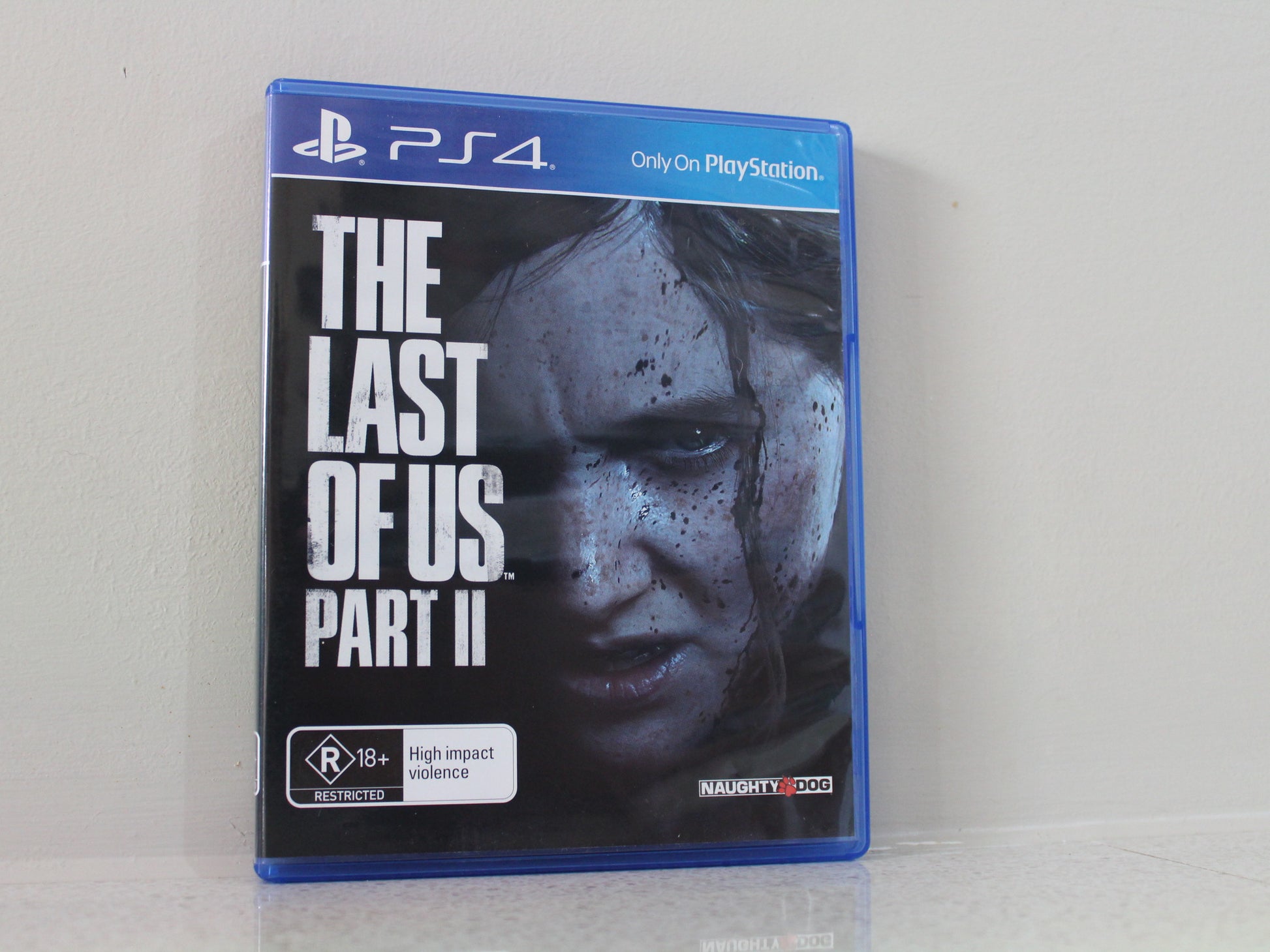 Game case for 'The Last of Us Part II' on a PlayStation 4 console.